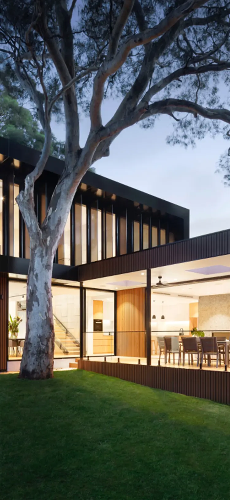 写真：緑に囲まれた２階建ての窓がたくさんある開放的な大きな家